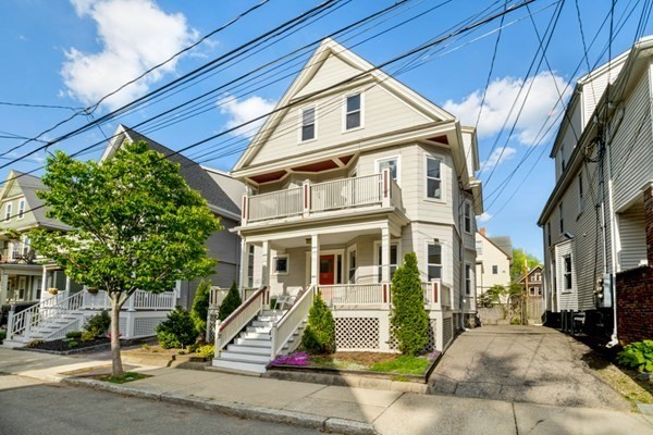 a view of a white house with large windows and a table