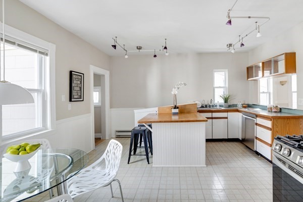 37 Bromfield Road Somerville, MA 02144 - Photo 15 of 39 a kitchen with stainless steel appliances kitchen island granite countertop a sink and cabinets