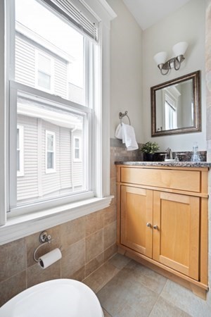 37 Bromfield Road Somerville, MA 02144 - Photo 17 of 39 a bathroom with a granite countertop toilet sink and mirror