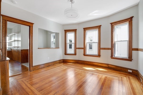 37 Bromfield Road Somerville, MA 02144 - Photo 29 of 39 a view of an empty room with window and wooden floor