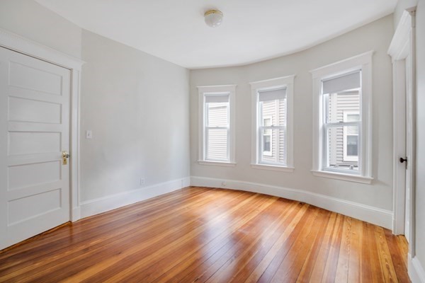 37 Bromfield Road Somerville, MA 02144 - Photo 32 of 39 a view of an empty room with wooden floor and a window