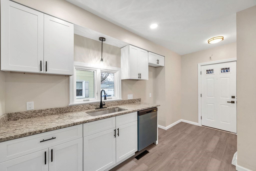 77 Daviston Street Springfield, MA 01108 - Photo 6 of 41 a kitchen with a sink dishwasher and white cabinets with wooden floor