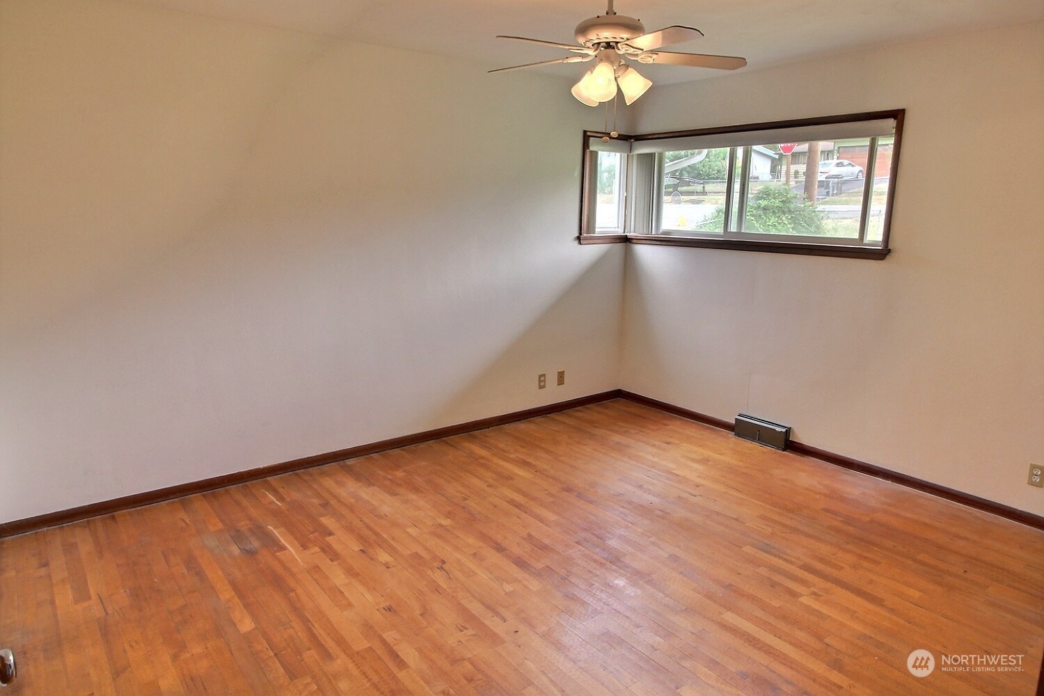 3619 Talbot Road South Renton, WA 98055 - Photo 16 of 27 a view of an empty room with wooden floor and a window