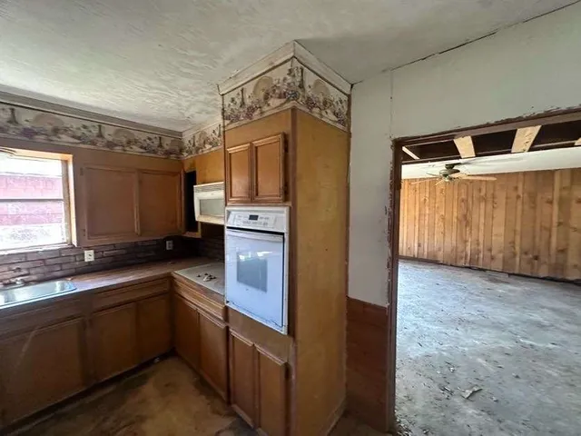 a kitchen with granite countertop cabinets stainless steel appliances a sink and a window
