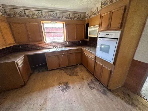 a kitchen with granite countertop cabinets stainless steel appliances a sink and a window