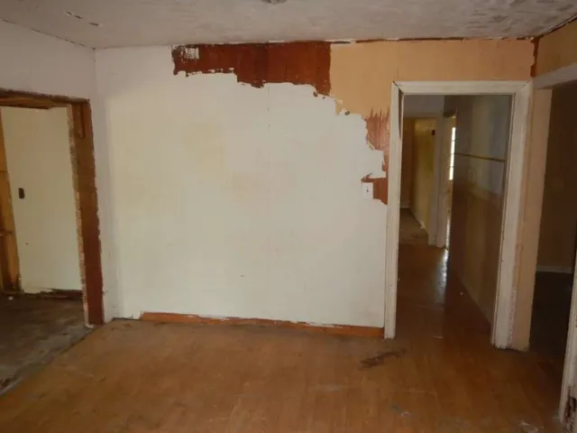 an empty room with a chandelier fan