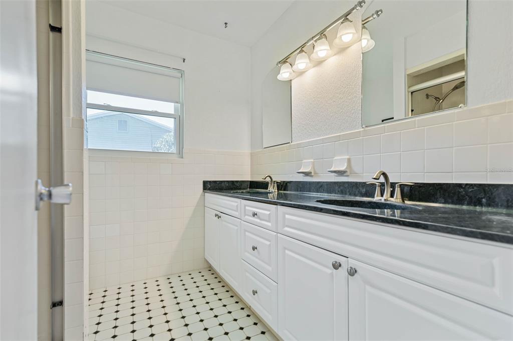 9 Crompton Place Palm Coast, FL 32137 - Photo 19 of 52 a bathroom with a sink a mirror and a shower