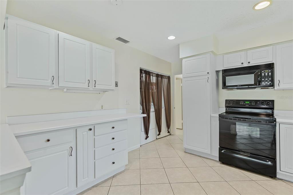 9 Crompton Place Palm Coast, FL 32137 - Photo 5 of 52 a kitchen with white cabinets and stainless steel appliances