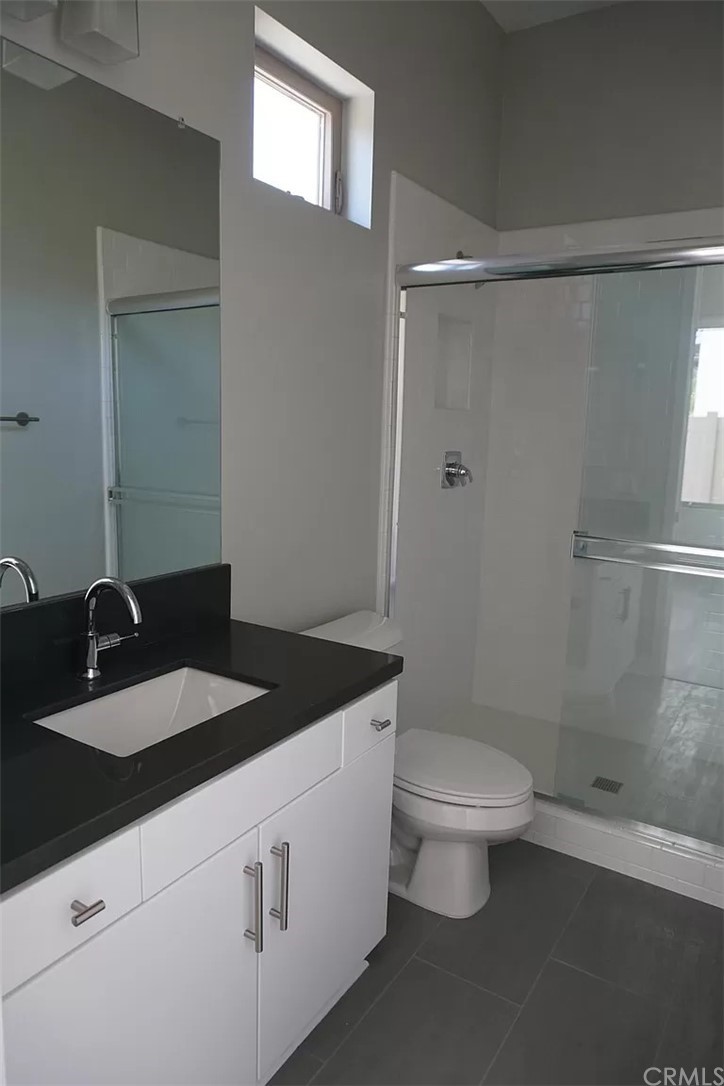 83 Ebb Tide Circle Newport Beach, CA 92663 - Photo 13 of 17 a bathroom with a granite countertop sink a toilet a shower and a mirror