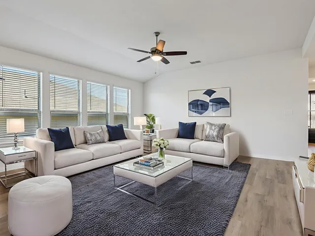 a living room with furniture a ceiling fan and a rug