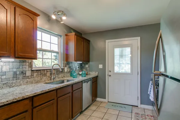 a bathroom with a granite countertop sink a mirror and a shower