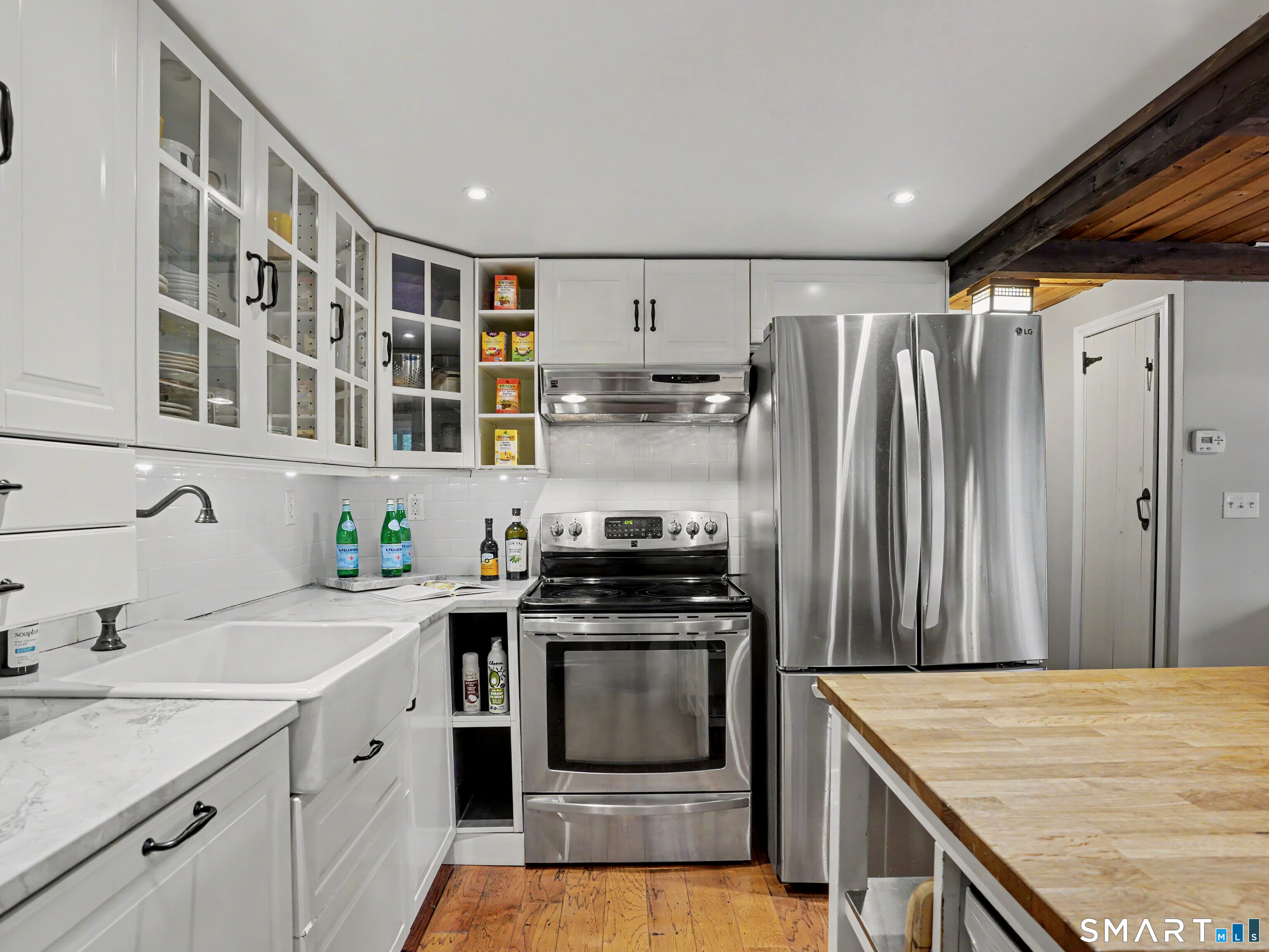 252 Bennetts Farm Road Ridgefield, CT 06877 - Photo 11 of 40 The kitchen itself is bright with sleek, white cabinets, a farm sink, marble & butcher block counters, all anchored by stainless steel appliances.