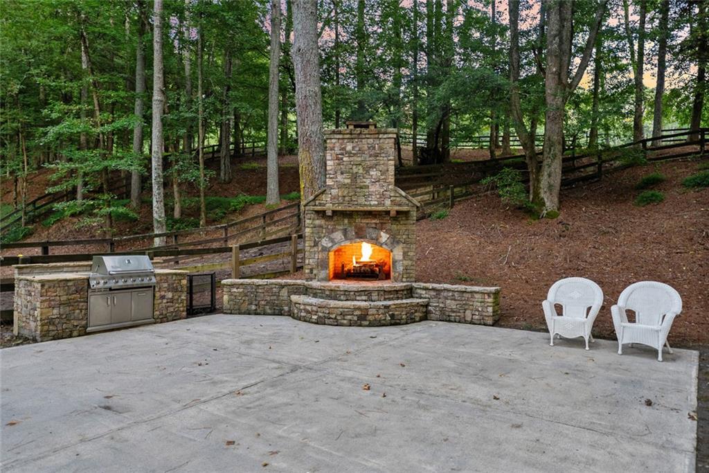 3309 Hamby Road Milton, GA 30004 - Photo 76 of 95 a view of a backyard with table and chairs potted plants and large tree