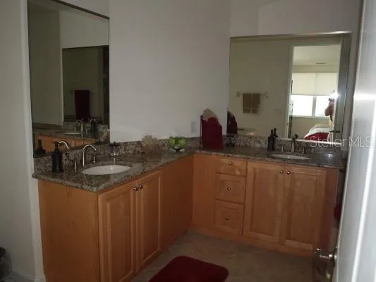 a bathroom with a granite countertop sink and a mirror