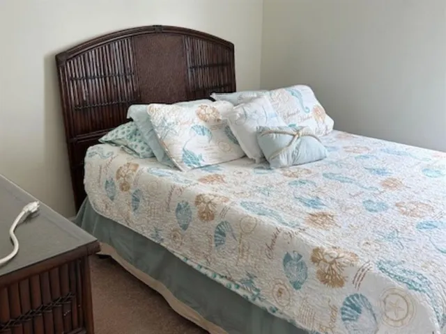 a bed sitting in a bedroom next to a wooden cabinet