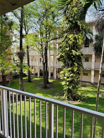 a view of a brick house with a large window and plants