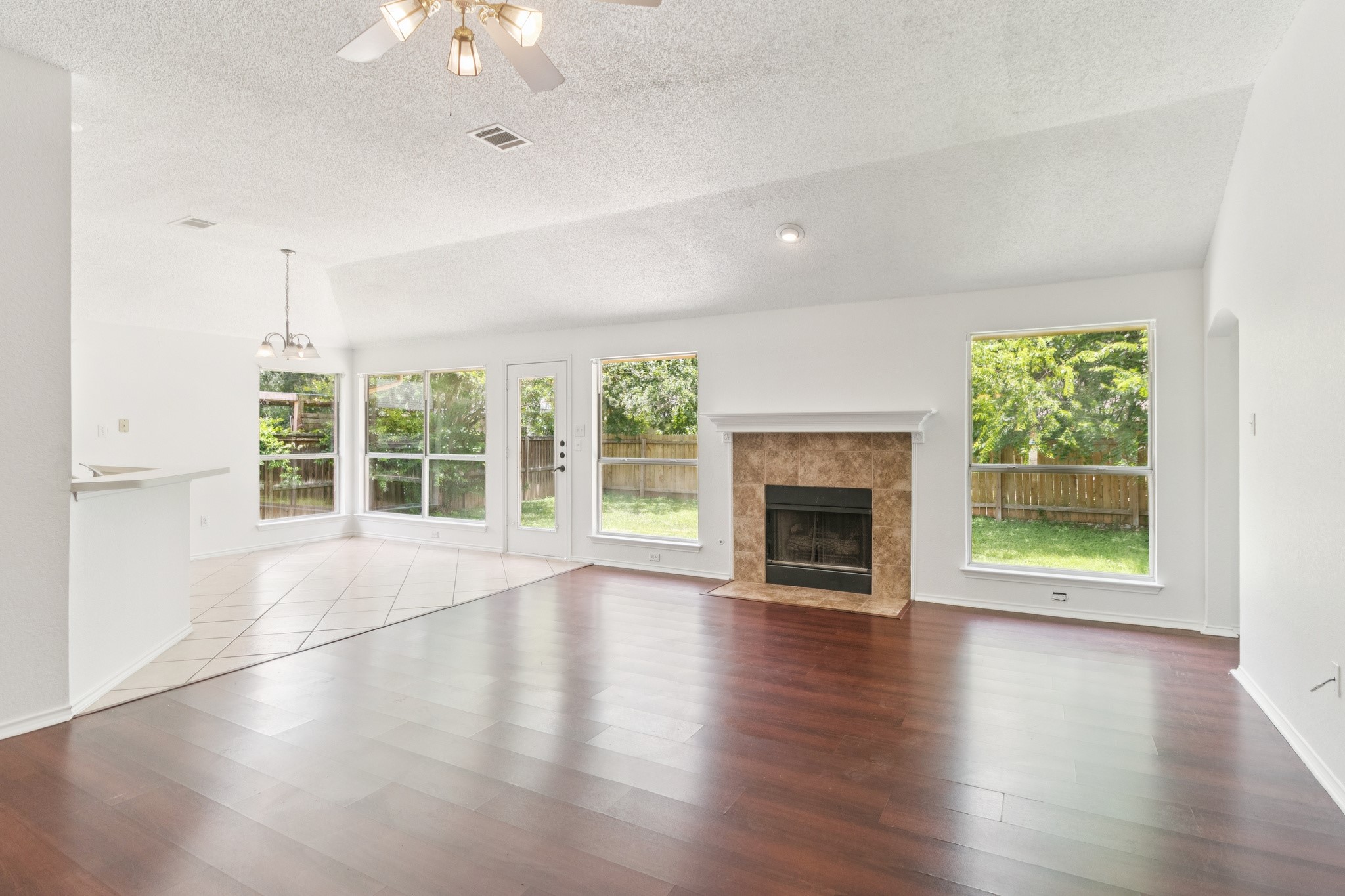 800 Mountain Ridge Drive Leander, TX 78641 - Photo 8 of 31 Rich hardwood flooring pairs with a classic tile fireplace under vaulted ceilings.