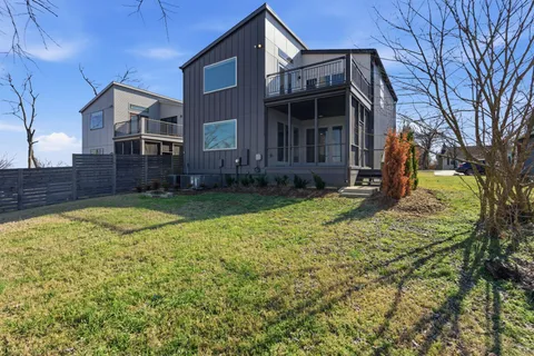 a kitchen with stainless steel appliances granite countertop a kitchen island and chairs in it