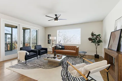 a living room with furniture and a view of kitchen