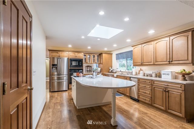 a kitchen with stainless steel appliances granite countertop a sink a stove a refrigerator and cabinets
