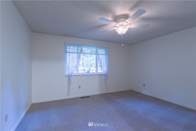 an empty room with a ceiling fan and a window