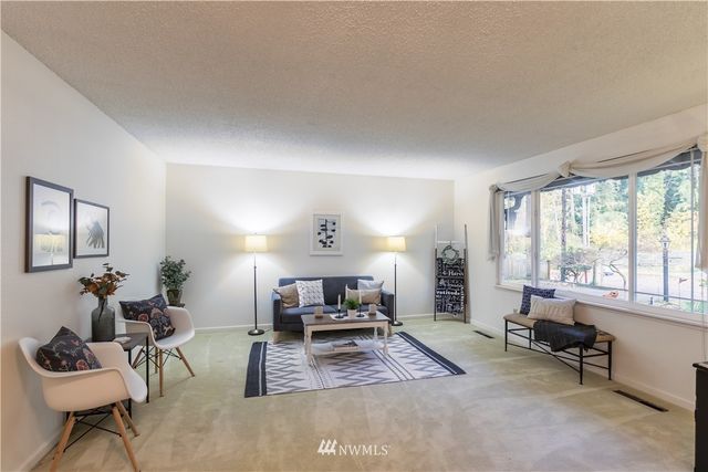 a living room with furniture and a table with kitchen appliances