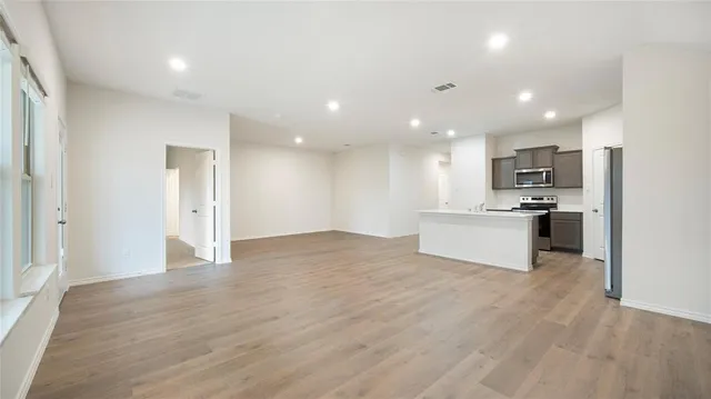 a view of kitchen with granite countertop stainless steel appliances refrigerator and microwave