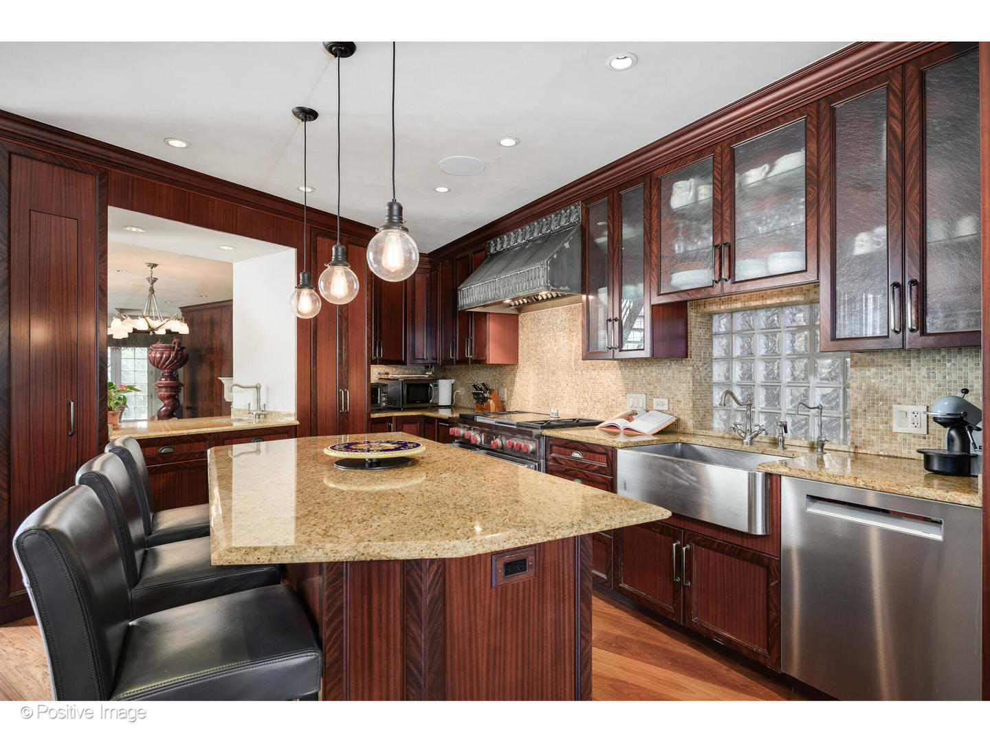 1811 North Howe Street Chicago, IL 60614 - Photo 14 of 42 a kitchen with a stove a sink a kitchen island with a dining table and chairs