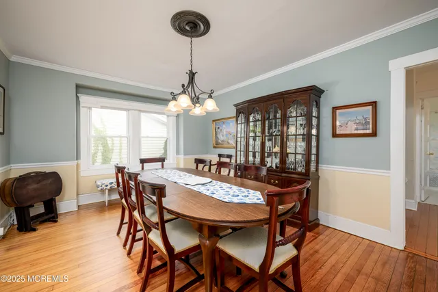 a kitchen with stainless steel appliances granite countertop a dining table chairs refrigerator and microwave