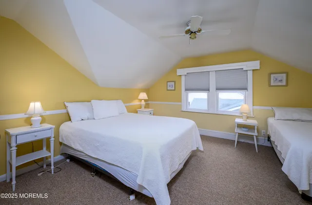 a bedroom with 2 bed and a ceiling fan