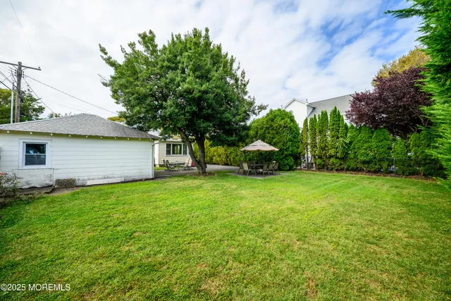 a view of a chair and table in backyard of the house