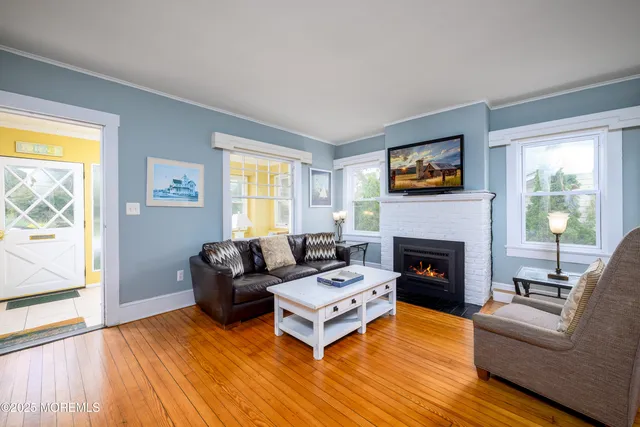 a living room with fireplace furniture and a wooden floor