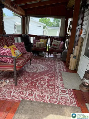 a living room with furniture a rug and a floor to ceiling window