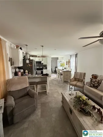 a living room with furniture and a dining table with kitchen view