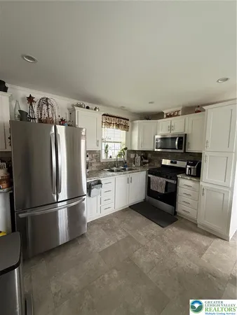 a kitchen with granite countertop stainless steel appliances and refrigerator