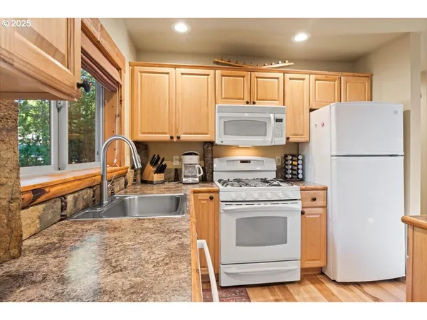 a kitchen with refrigerator a stove a sink and a microwave