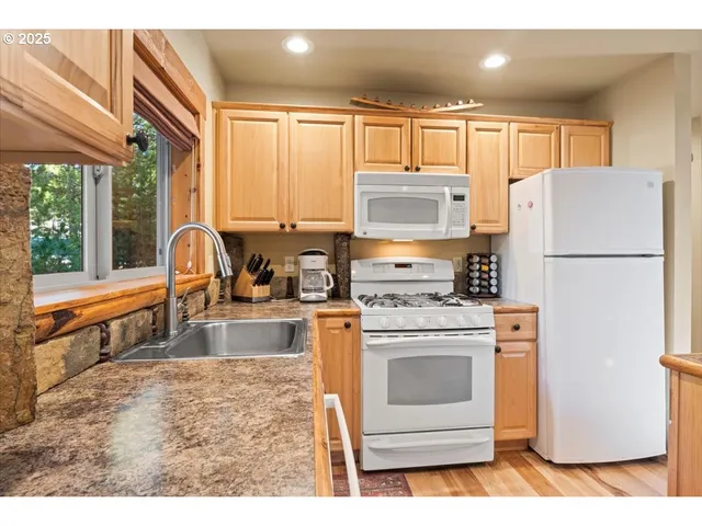 a kitchen with refrigerator a stove a sink and a microwave