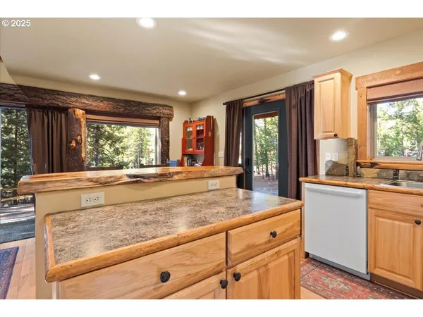 a view of kitchen with granite countertop cabinets and outdoor view