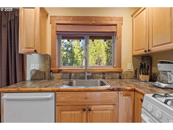 a kitchen with granite countertop a sink a counter top space and cabinets