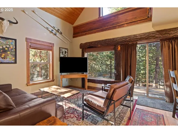 a living room with furniture a flat screen tv and a floor to ceiling window