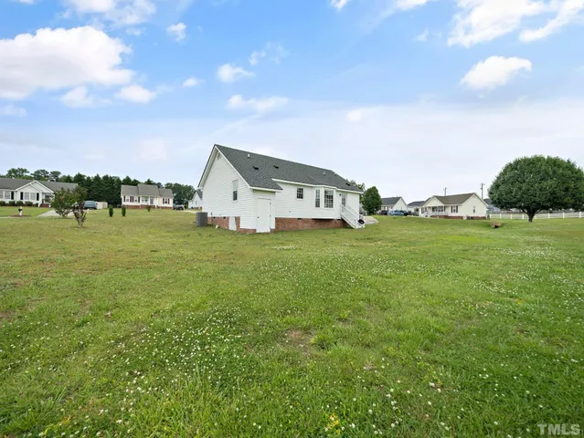 a view of a house with a yard and sitting area