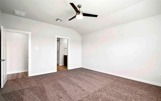 an empty room with a window and a ceiling fan