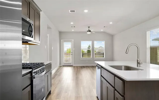 a kitchen with stainless steel appliances granite countertop a sink and a stove