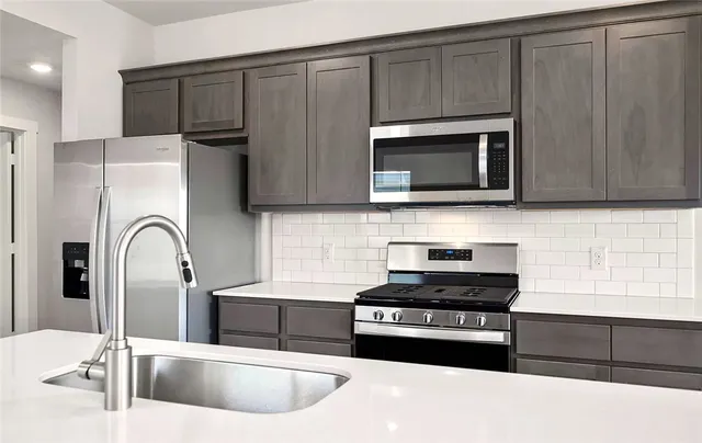 a kitchen with stainless steel appliances wooden cabinets and a sink