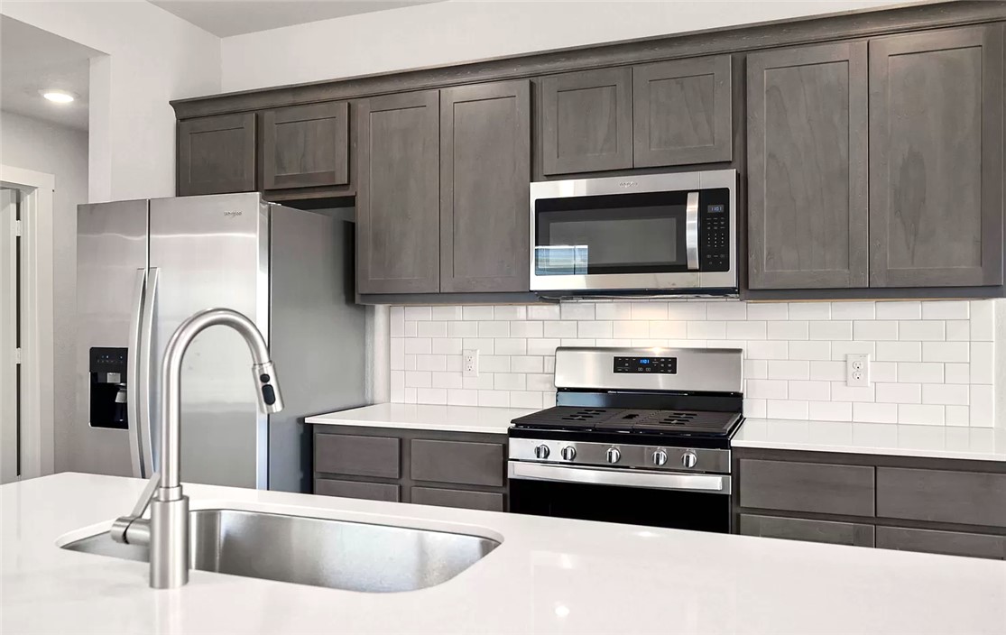 925 Kickapoo Lane College Station, TX 77845 - Photo 6 of 20 a kitchen with stainless steel appliances wooden cabinets and a sink