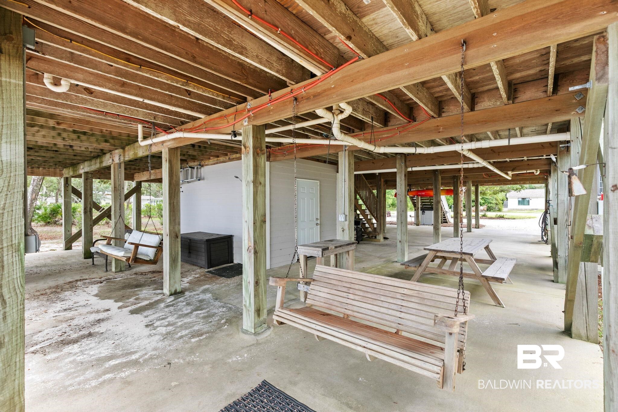 6802 Shore Drive Elberta, AL 36530 - Photo 6 of 34 Covered ground-level space featuring a concrete slab, exposed wood beam construction, and visible utility lines