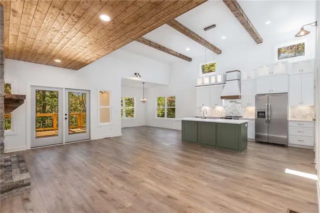 an empty room with wooden floor fireplace and windows
