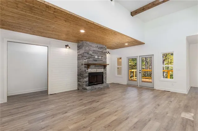 a view of empty room with fireplace and wooden floor