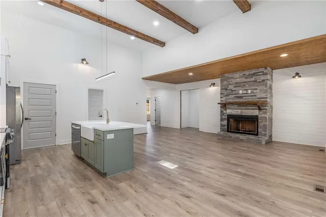 a view of open kitchen with a sink and dishwasher with wooden floor