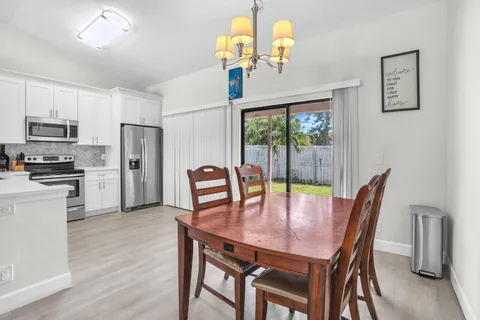 a view of a dining room with furniture a chandelier and wooden floor